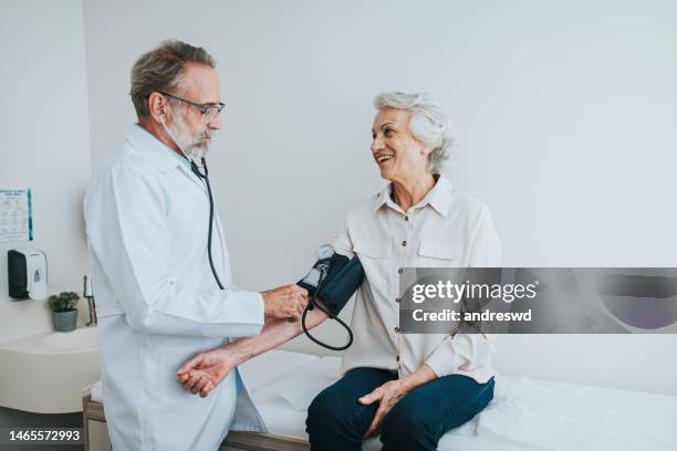 senior patient measuring blood pressure in arm - outpatient care stock pictures, royalty-free photos & images