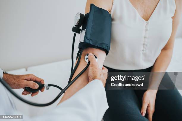 measuring patient's body pressure - high blood pressure stock pictures, royalty-free photos & images