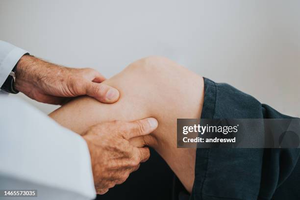 patient with knee pain in doctor's office - knie stockfoto's en -beelden