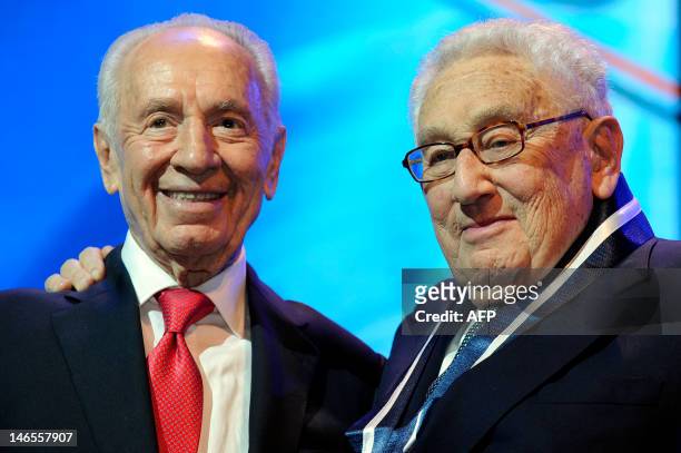 Israeli President Shimon Peres stands next to former US Secretary of State Henry Kissinger after awarding him the medal of honour during the 4th...