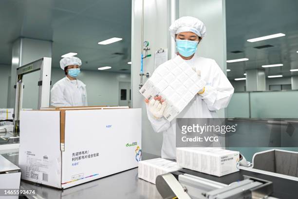 Employees work on the production line of drug "XIANNUOXIN", which is intended to be used for the treatment of adults infected with mild to moderate...