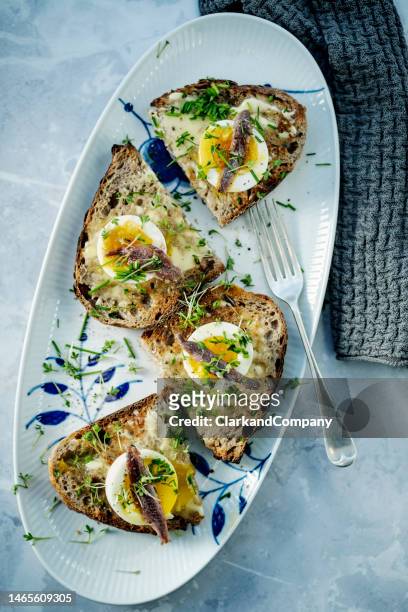 soft boiled eggs with anchovies overhead view - sourdough bread stock pictures, royalty-free photos & images