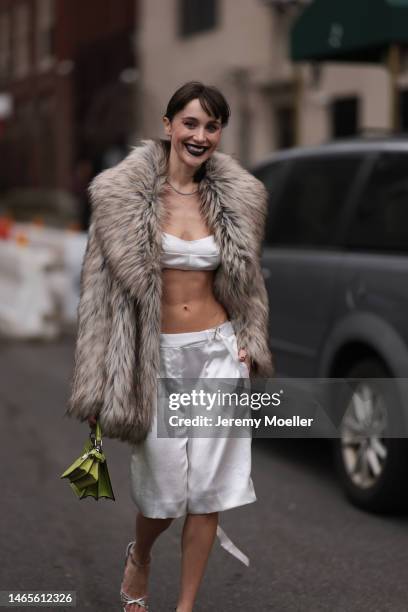 Mary Leest seen wearing diamonds earrings, diamonds necklace, white v-neck / cropped tank-top, matching white silk suit shorts, brown fake fur...