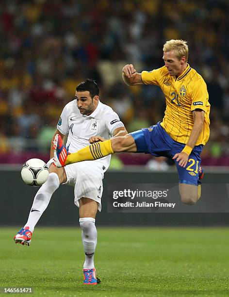 Adil Rami of France is challenged by Christian Wilhelmsson of Sweden during the UEFA EURO 2012 group D match between Sweden and France at The Olympic...