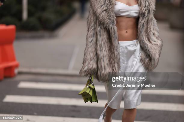 Mary Leest seen wearing white v-neck / cropped tank-top, matching white silk suit shorts, brown fake fur oversized coat, Fendi Peekaboo lime green...