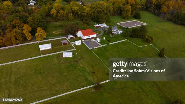 Aerial of white farm and barn with white fence outside of Doylestown and Quakertown in Bucks County Pennsylvania.