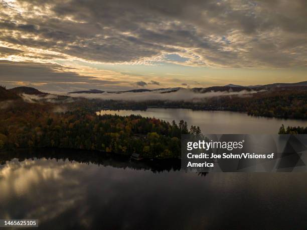 Aerial view above clouds of Blue Mountain Lake at sunrise in Adirondack, New York State.