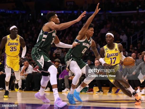 Dennis Schroder of the Los Angeles Lakers dribbles in front of MarJon Beauchamp and Giannis Antetokounmpo of the Milwaukee Bucks at Crypto.com Arena...
