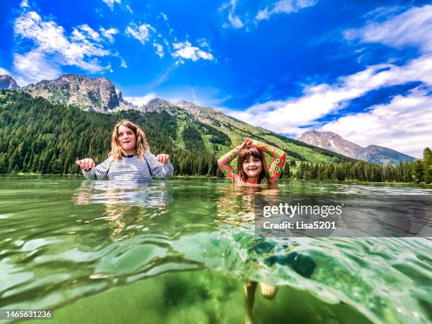 kinderschwimmen im string lake, im grand teton national park, unter wasser, im gletschersee und mit der großen teton-bergkette; - grand teton national park stock-fotos und bilder