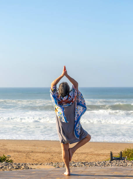 Woman performing yoga Tree pose Vrikshasanayoga, Atlantic Ocean   Morocco, north Africa. (Photo by: Geography Photos/Universal Images Group via Getty Images)