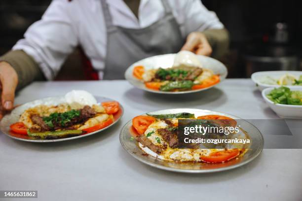 turkish manisa kebap served on pita bread covered with sauce and yogurt. - serving size stock pictures, royalty-free photos & images
