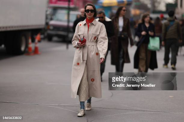 Marina Ingvarsson seen wearing Loewe black squared sunglasses, red ribbed wool turtleneck pullover, beige with embroidered red and brown circle print...