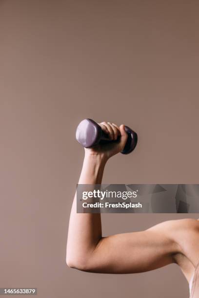 une femme méconnaissable faisant de l’exercice avec un haltère - poids-et-haltères photos et images de collection