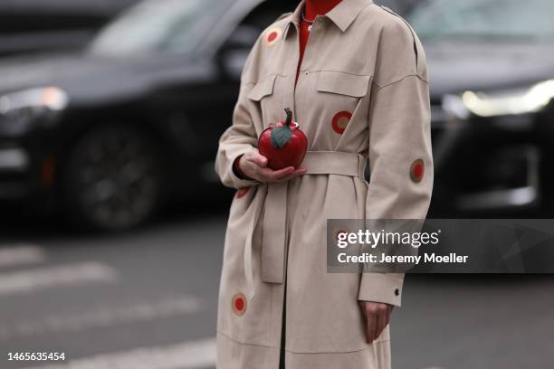 Marina Ingvarsson seen wearing, red ribbed wool turtleneck pullover, beige with embroidered red and brown circle print pattern belted long trench...