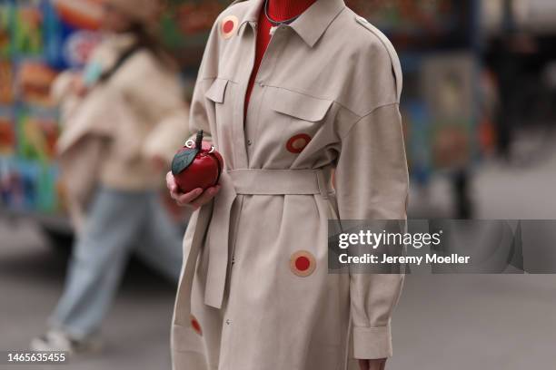 Marina Ingvarsson seen wearing, red ribbed wool turtleneck pullover, beige with embroidered red and brown circle print pattern belted long trench...