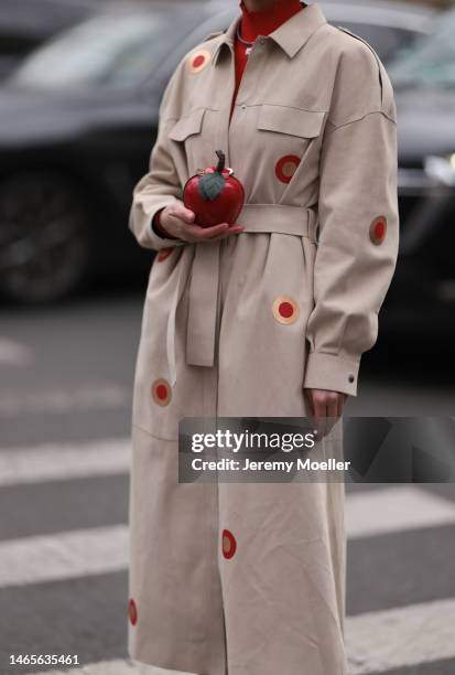 Marina Ingvarsson seen wearing, red ribbed wool turtleneck pullover, beige with embroidered red and brown circle print pattern belted long trench...