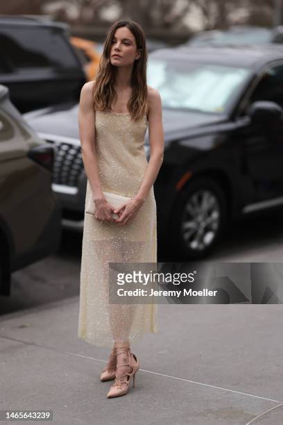 Sylvia Hoeks seen wearing a pale yellow embroidered sequined long tube dress, white latte shiny leather crocodile print pattern clutch, beige shiny...