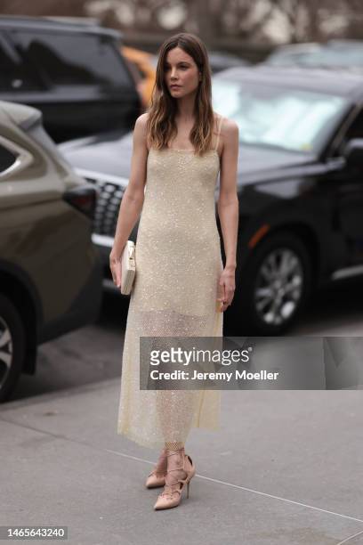 Sylvia Hoeks seen wearing a pale yellow embroidered sequined long tube dress, white latte shiny leather crocodile print pattern clutch, beige shiny...