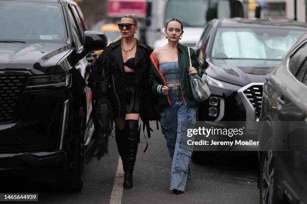 Olga Ferrara wears purple futurist sunglasses from Ouay, gold earrings, a gold large chain pendant necklace, a black bra underwear, a black silk...