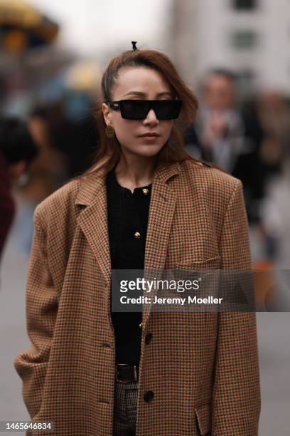 Guest wears Celine black square sunglasses, Miu Miu gold earrings, black tweed with gold buttoned jacket, yellow with brown / black houndstooth print...