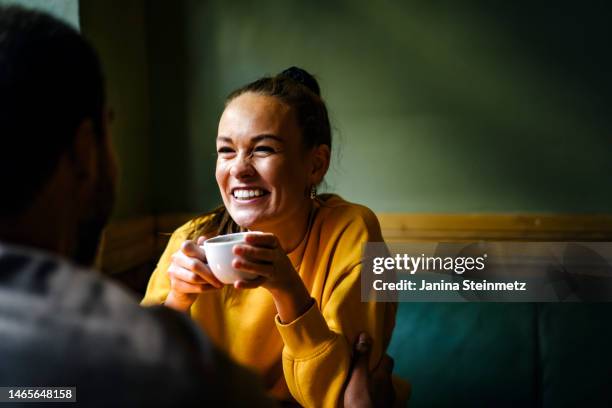 female laughing with friend while drinking coffee - enjoying with friends stock pictures, royalty-free photos & images