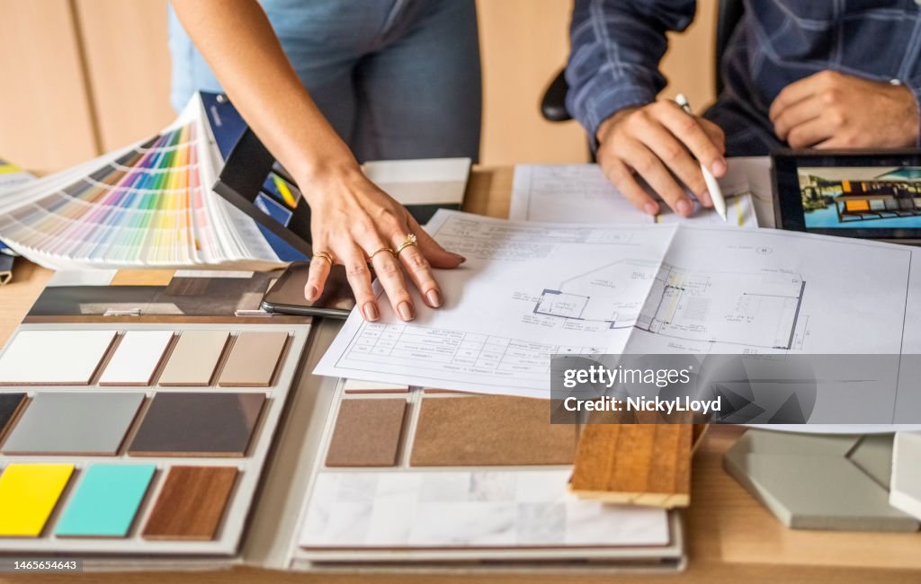 オフィスの女性の同僚と建物の青写真について話し合う建築家の接写