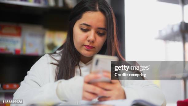 Using Phone While Study High School Student Using Smart Phone While Studying In Library High ...