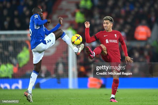 Roberto Firmino of Liverpool and Abdoulaye Doucoure of Everton battle for possession during the Premier League match between Liverpool FC and Everton...