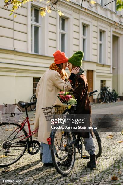 full length shot of female couple engaged in an affectionate moment - winter berlin stockfoto's en -beelden