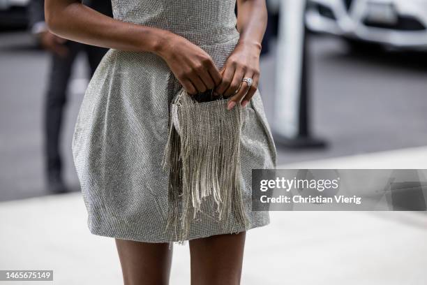 Afiya Bennett waers silver off shoulder dress, bag with fringes outside Bronx & Banco during New York Fashion Week on February 12, 2023 in New York...