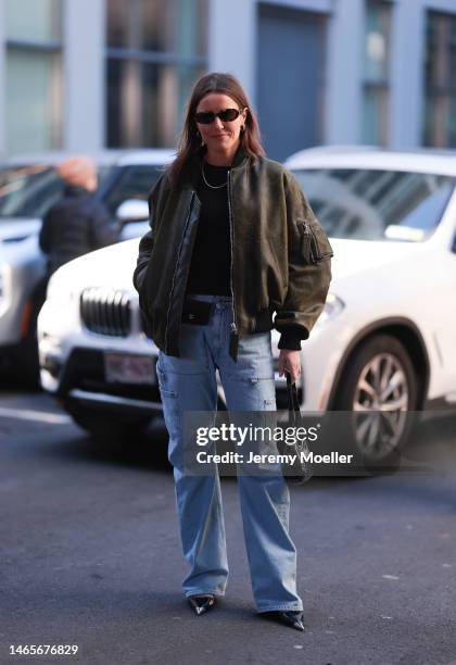 Chloe Street wears a oversized green leather bomber jacket, denim cargo jeans, a Chanel black belt bag, a black bag, Prada kitten heels, brown...