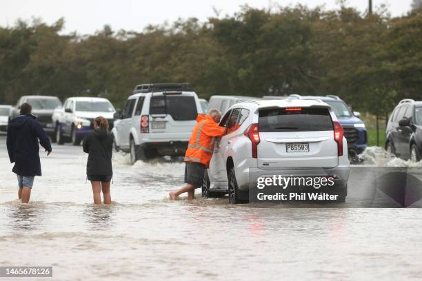 Traffic drives through floodwaters in Kumeu on February 14, 2023 in Auckland, New Zealand. New Zealand has declared a national state of emergency...