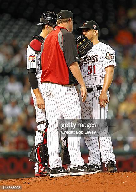 Pitching coach Doug Brocail talks with pitcher Wandy Rodriguez of the Houston Astros and catcher Jason Castro during a baseball game against the...