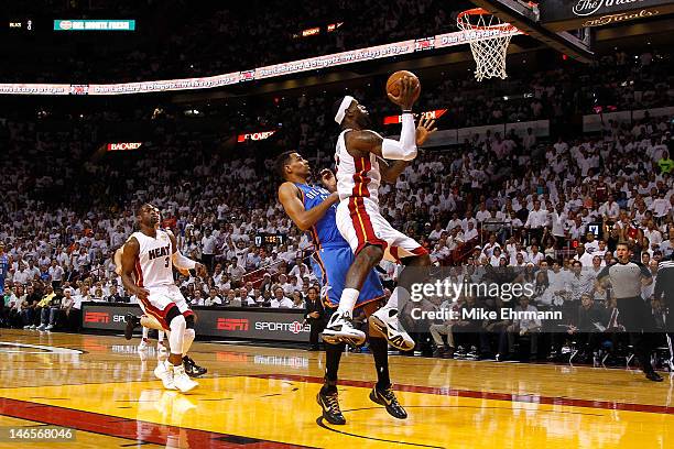 LeBron James of the Miami Heat drives for a shot attempt in the first quarter against Thabo Sefolosha of the Oklahoma City Thunder in Game Four of...