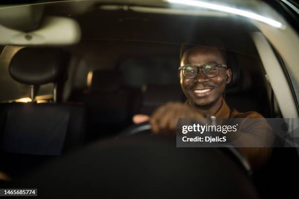 handsome african american man driving his car. - car dealership test drive stock pictures, royalty-free photos & images