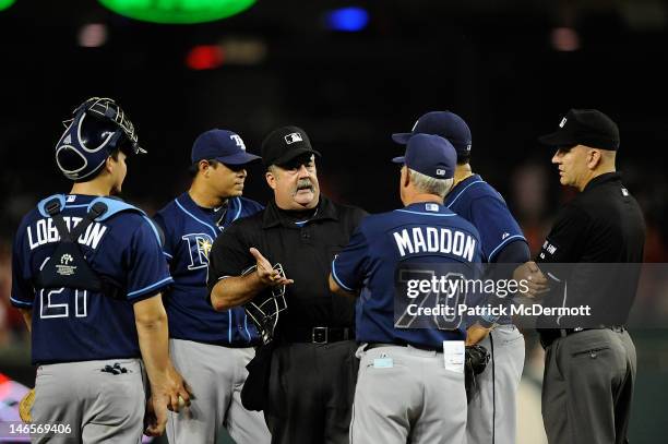 Home plate umpire Tim Tschida talks with Tampa Bay Rays manager Joe Maddon about the glove of Joel Peralta during the eighth inning against the...