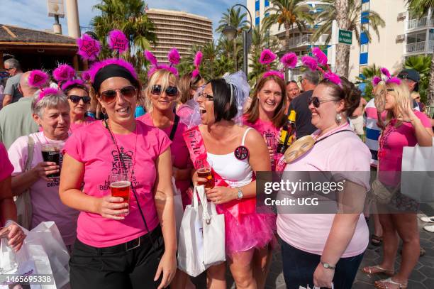 Group of young British women on a hen weekend having fun at waterfront bar in Benidorm, Spain.