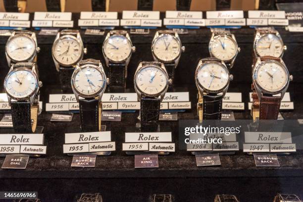 Vintage Rolex watches in shop display window, London, UK.