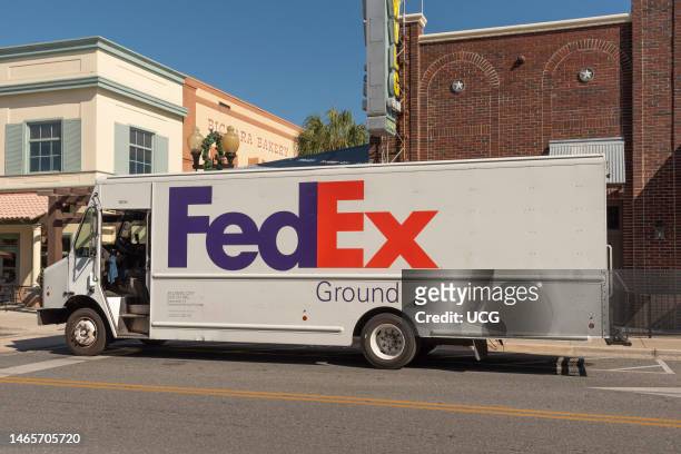 The Villages, Florida, International packet and parcel carrier delivery truck making a stop in a Florida town center.