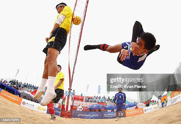 Uthen Kukheaw of Thailand kicks over the net against Dong Han of China during the Beach Sepaktakraw Men's Regu Preliminary match between Thailand and...