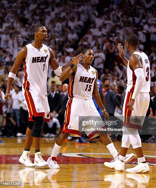 Chris Bosh, Mario Chalmers and Dwyane Wade of the Miami Heat celebrate in the fourth quarter against the Oklahoma City Thunder in Game Four of the...