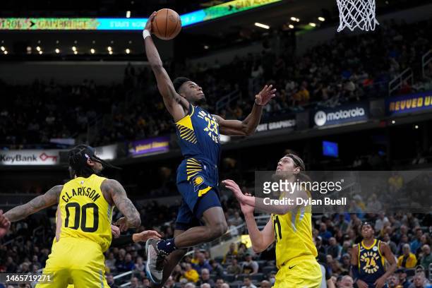 Aaron Nesmith of the Indiana Pacers dunks the ball over Jordan Clarkson and Kelly Olynyk of the Utah Jazz in the first quarter at Gainbridge...