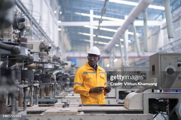 male manufacturers african engineer and tablet working at plastic bag factory - automatic stock pictures, royalty-free photos & images