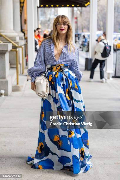 Julianne Hough wears high waisted belted blue skirt with floral print, white bag, stripped button shirt outside Carolina Herrera during New York...
