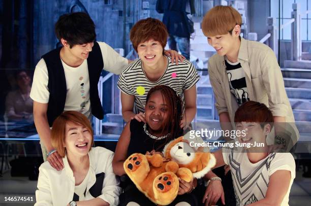 Year old American girl Donica Streling smiles with members of SHINee at SM Entertainment head office on June 20, 2012 in Seoul, South Korea. Donica,...