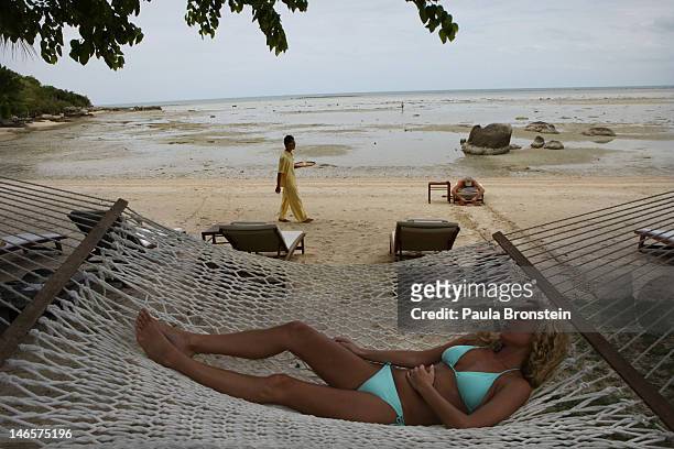 Woman rests on a hammock at the beach at the Kamalaya Wellness Sanctuary June 18, 2012 . Thailand's official tourism body, the Tourism Authority of...