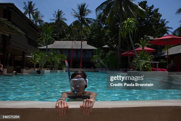Guest tries out her new snorkeling gear practicing in the pool at the Anantara Rasananda resort June 18, 2012 on the island of Koh Phangan off the...