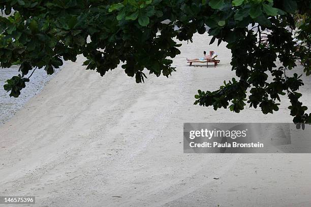 Man reads a book on the beach at the Kamalaya Wellness Sanctuary June 18, 2012 . Thailand's official tourism body, the Tourism Authority of Thailand...