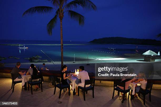 Tourists enjoy dinner along the water at the Anantara Lawana resort on Koh Samui, June 18, 2012 . Thailand's official tourism body, the Tourism...