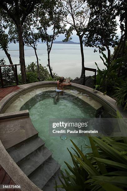 Woman reads a book in a splash pool overlooking the water at the Kamalaya Wellness Sanctuary June 18, 2012 . Thailand's official tourism body, the...